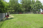 A large grassy area surrounded by chain link fence.