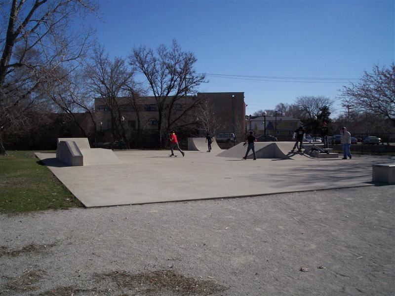 Youths skateboarding on a large concrete park.